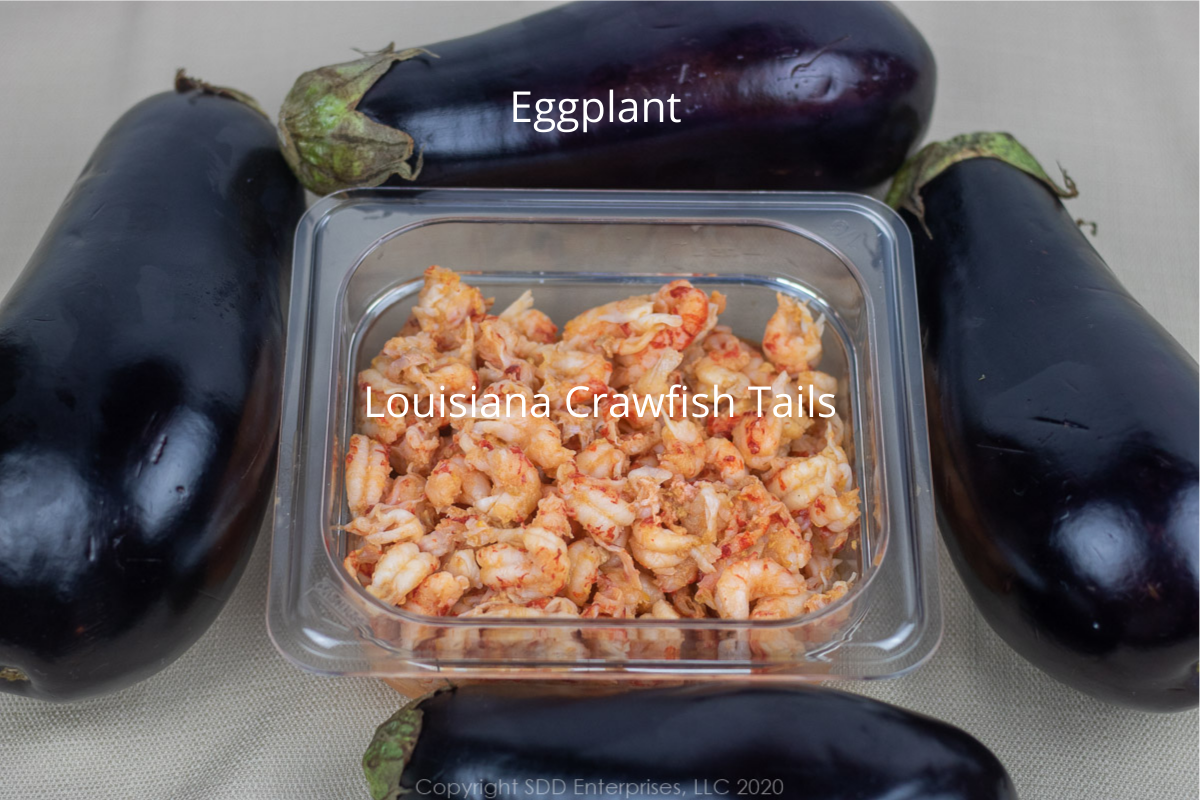 crawfish tails in a prep bowl and four whole eggplants