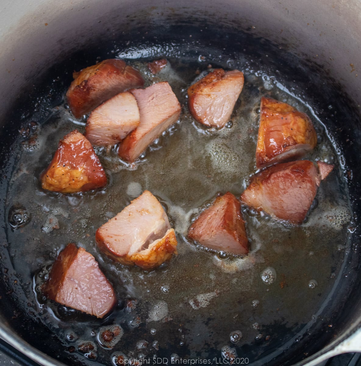 tasso frying in bacon grease in a dutch oven