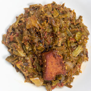 stewed okra with ham and tomatoes in a white bowl