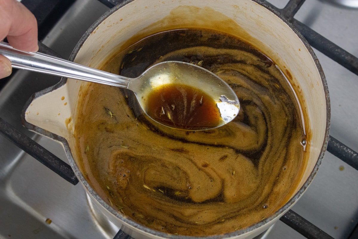 cane syrup sauce with a spoon in a small sauce pan