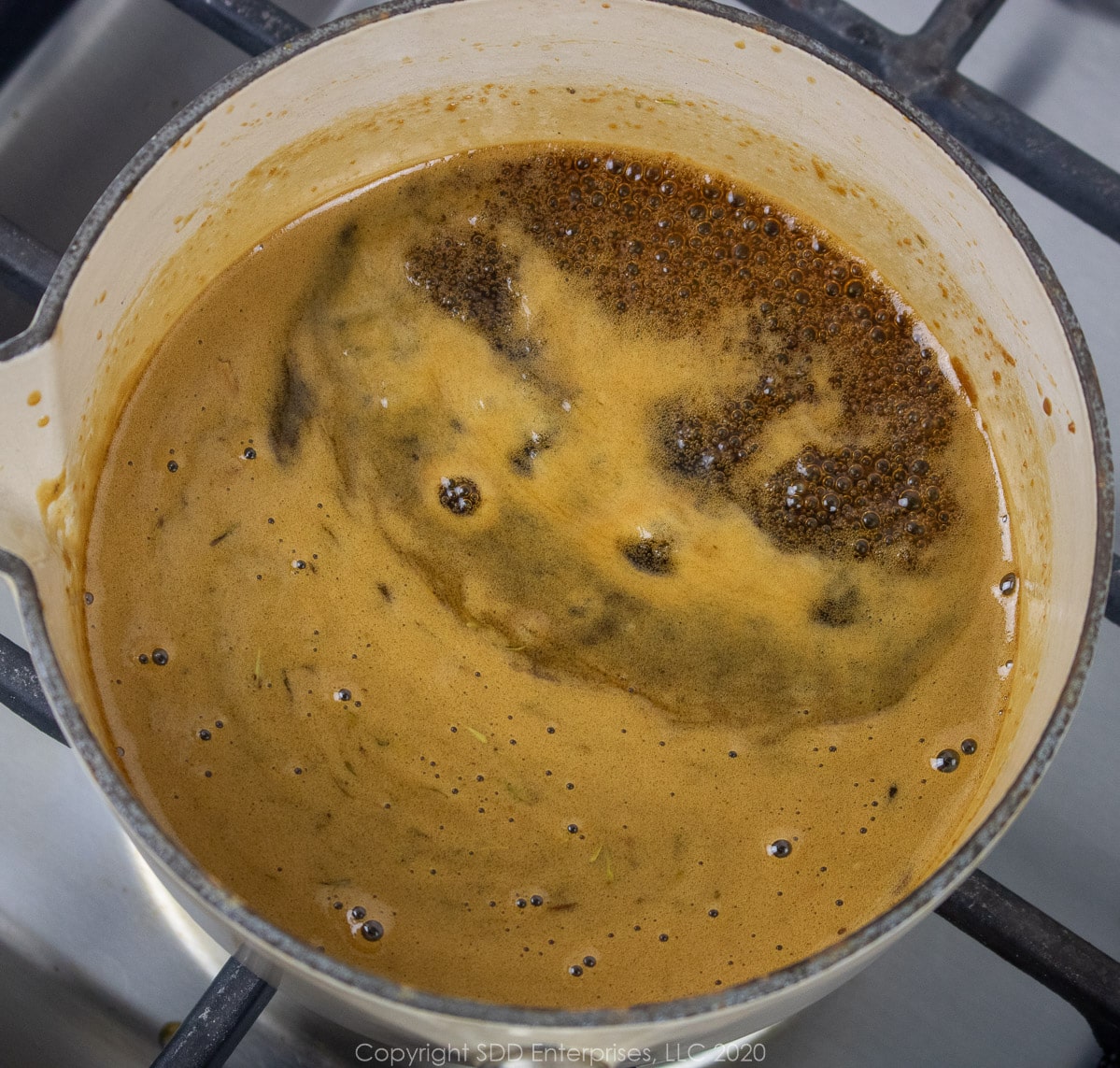 cane syrup sauce simmering in a small sauce pan