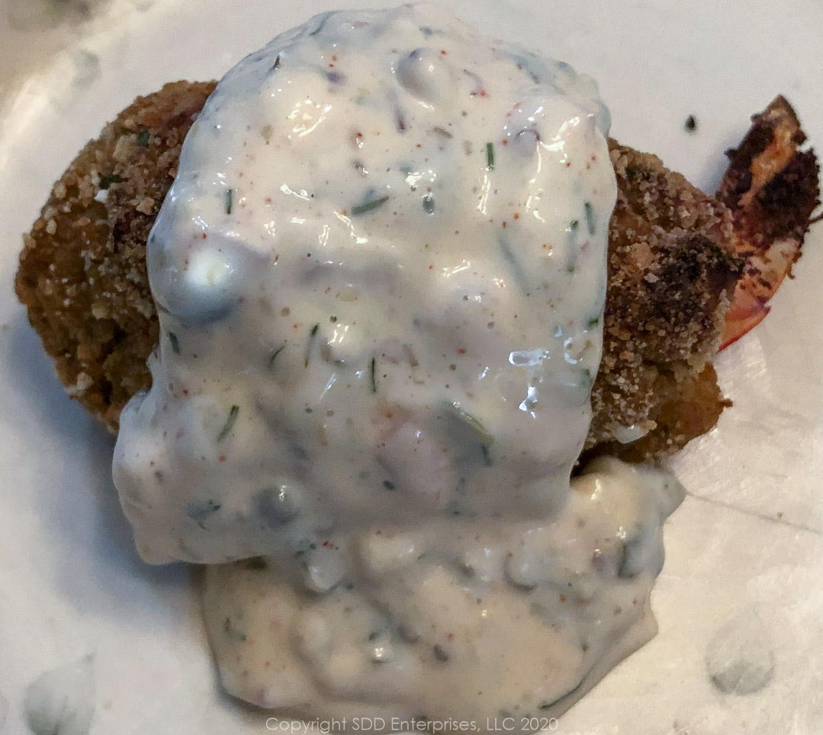 creole tartar sauce poured over a crab meat stuffed shrimp