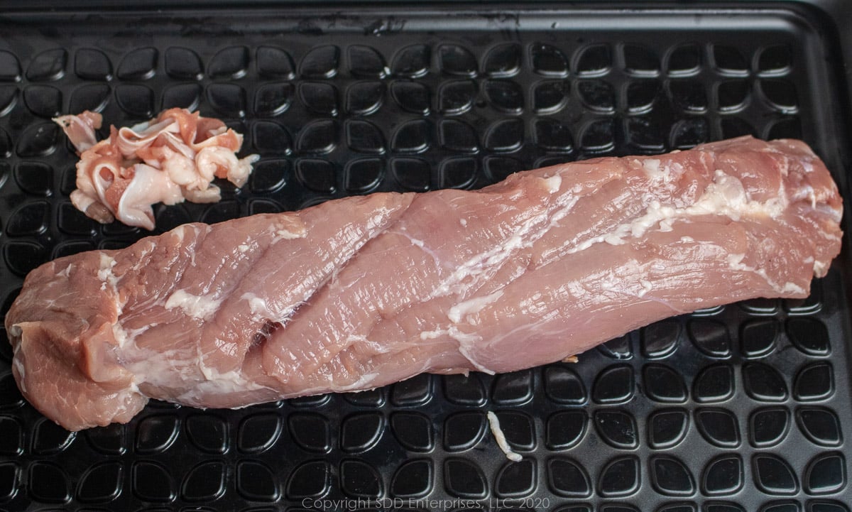 trimmed pork tenderloin on a prep board