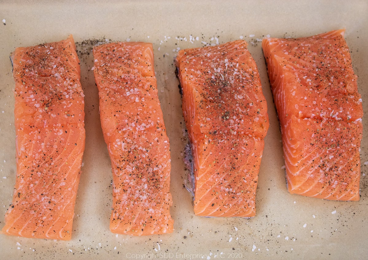 salmon fillets with kpsher salt and pepper on parchment