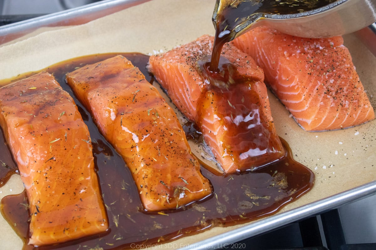 cane syrup sauce being poured over salmon fillets