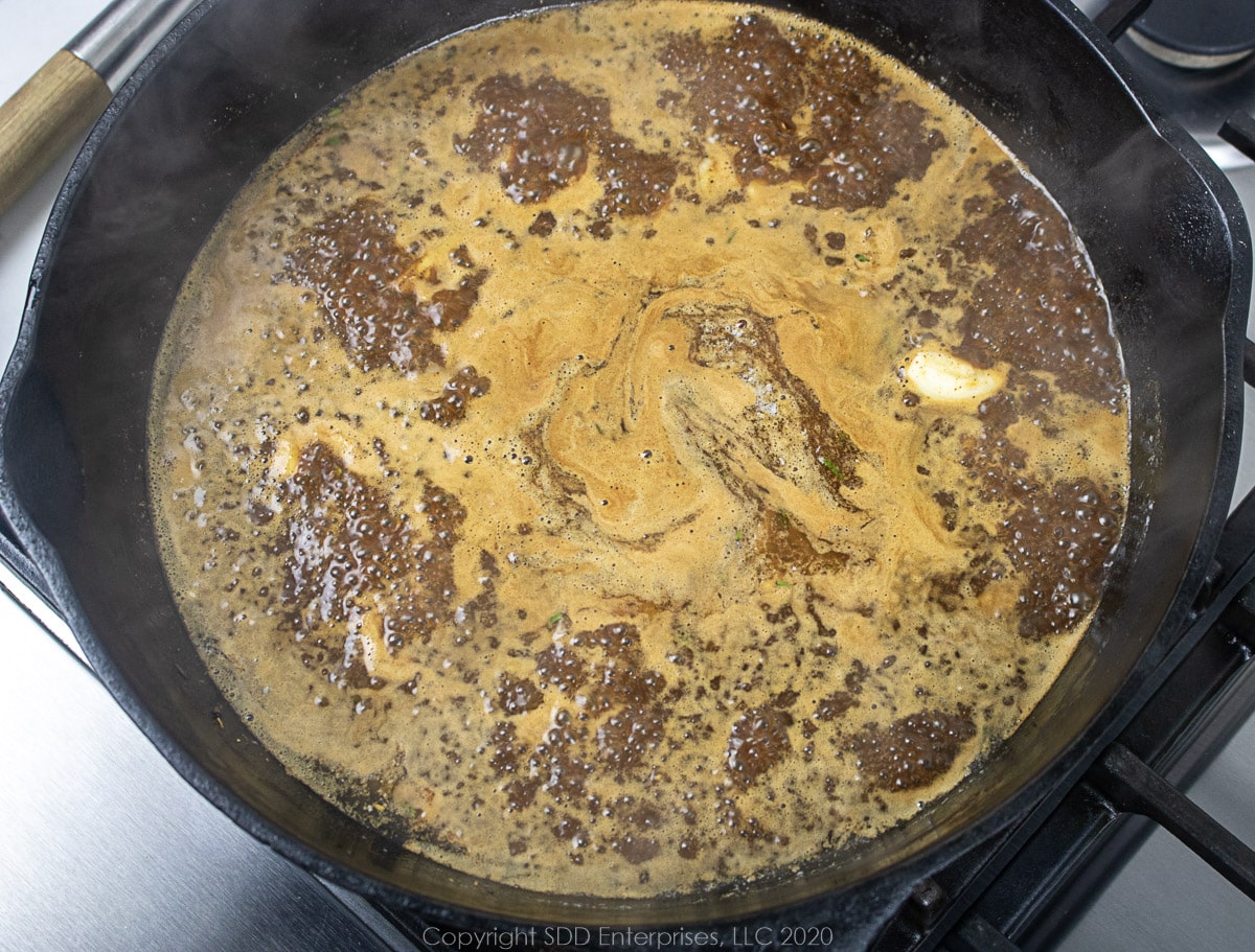 simmering sauce for barbecued shrimp in a cast iron skillet