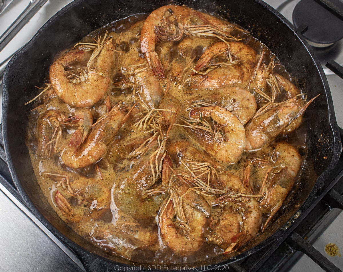 barbecued shrimp simmering in a cast iron skillet