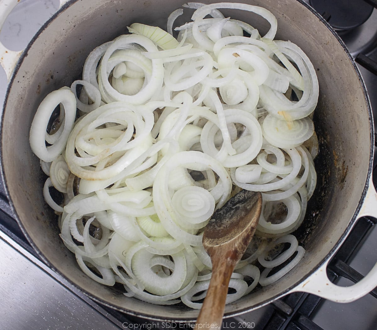 sliced yellow onions in a dutch oven