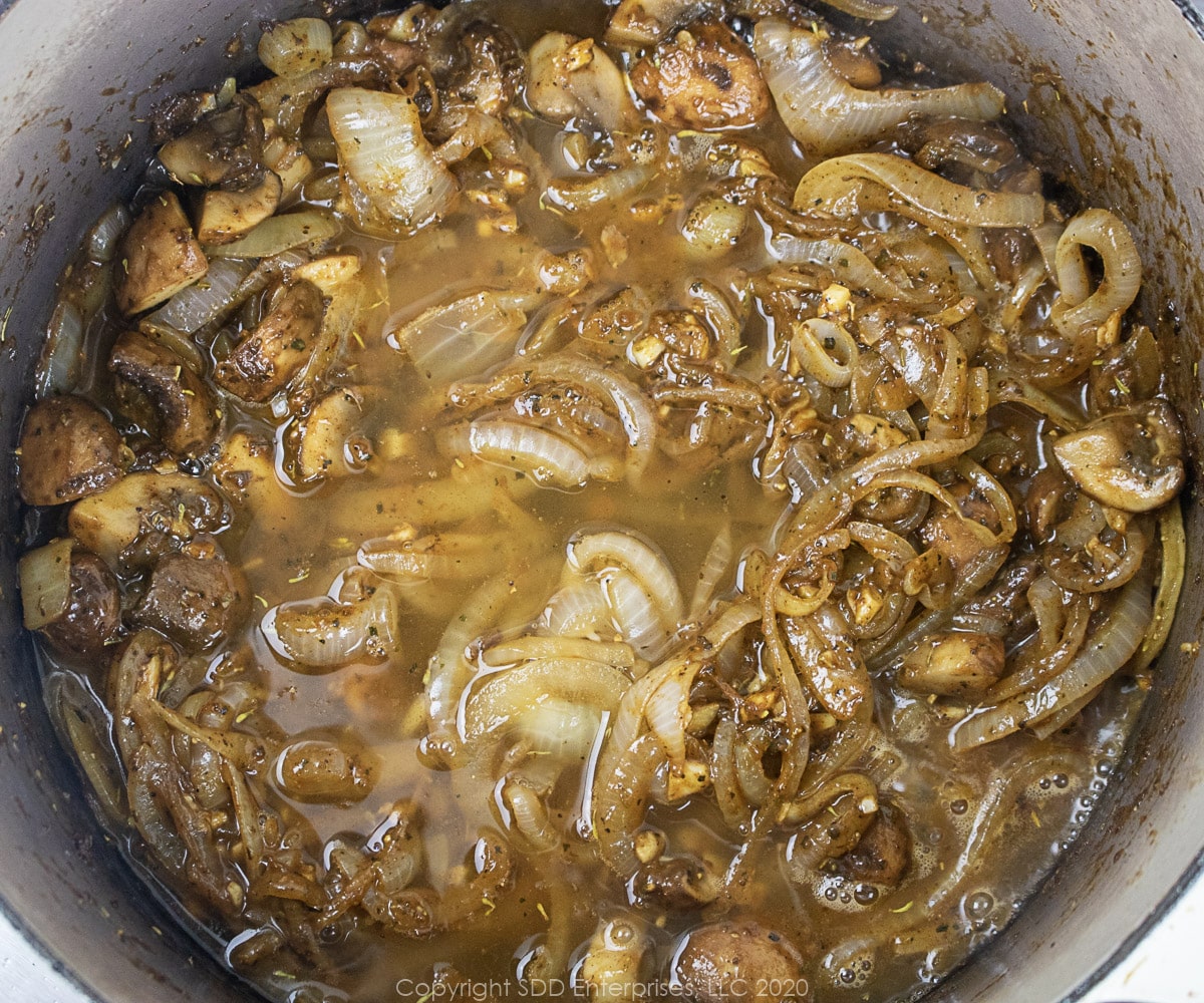 white wine added to dutch oven with spices, mushrooms and onions