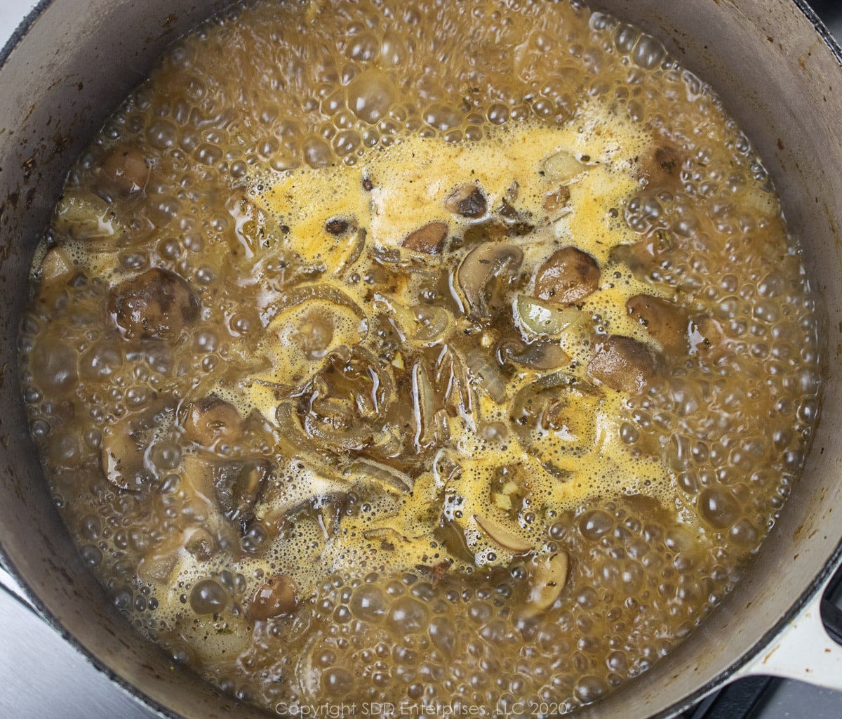 stock simmering with vegetables in  dutch oven