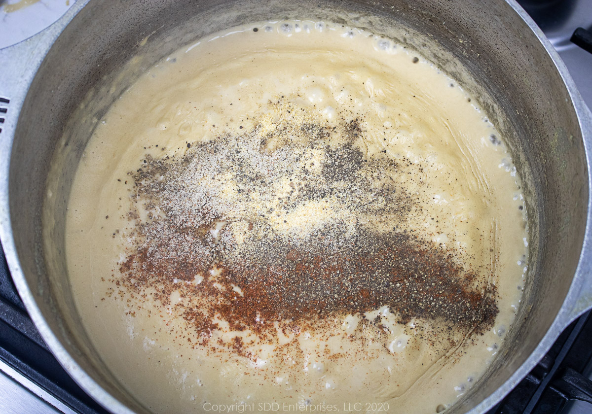 seasonings added to cream sauce in a dutch oven