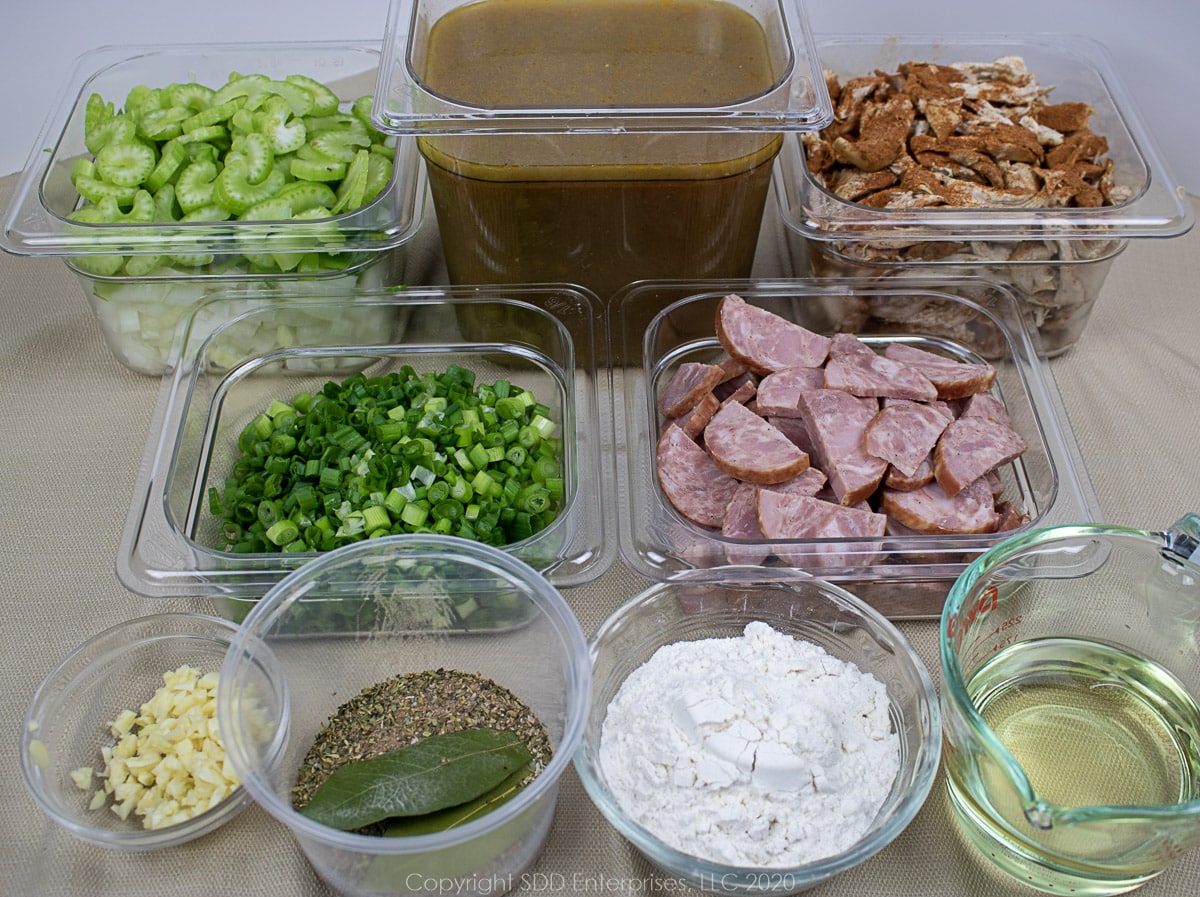 ingredients for chicken and andouille gumbo in individual prep dishes
