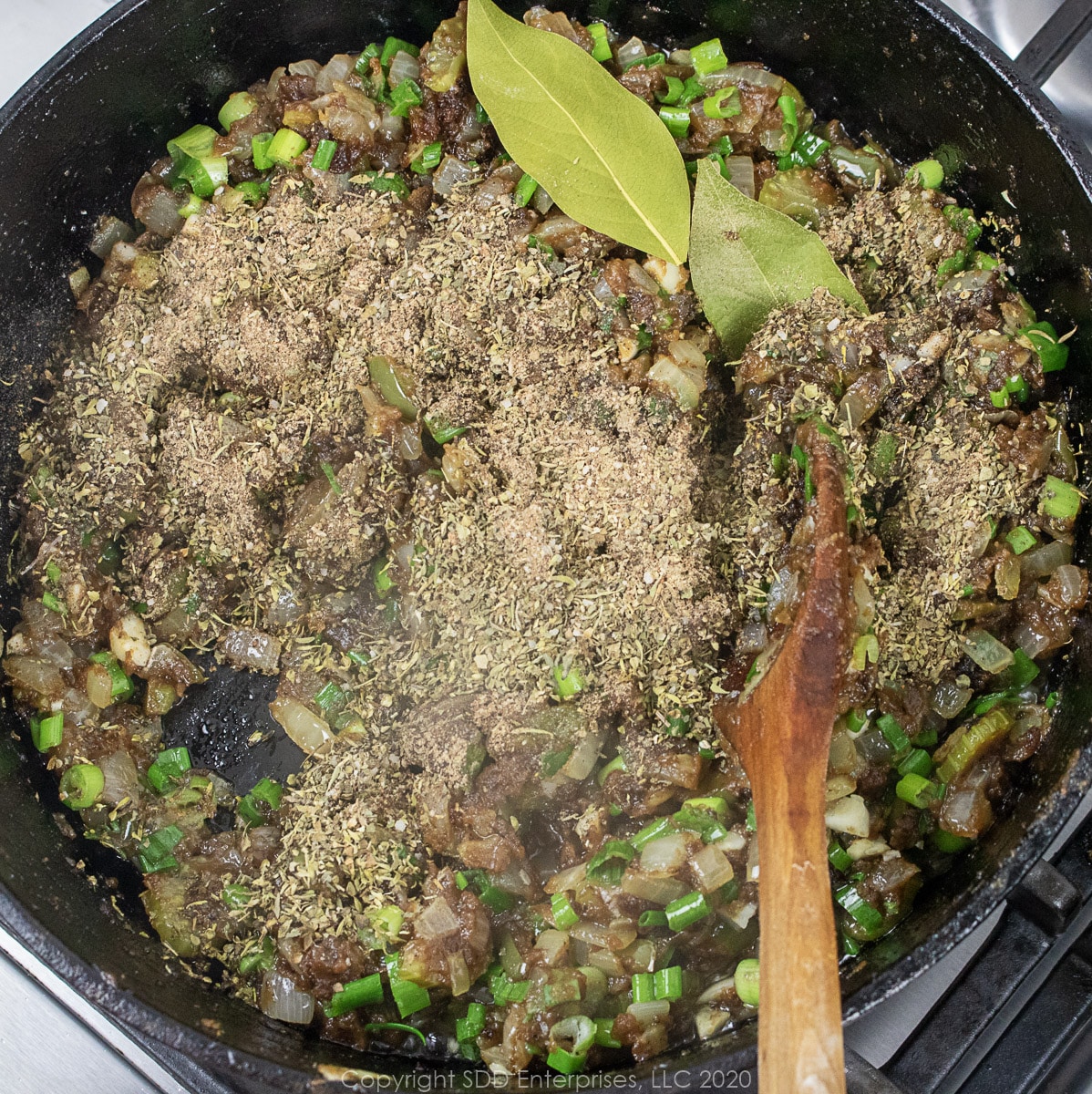herbs and spices added to cooking roux and vegetables in a dutch oven