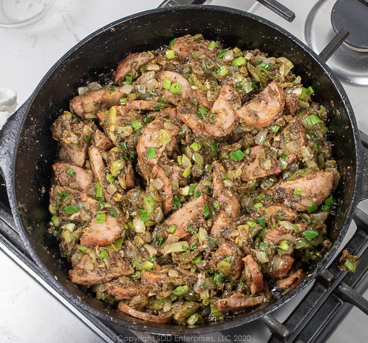 sausage added to seasonings in a dutch oven