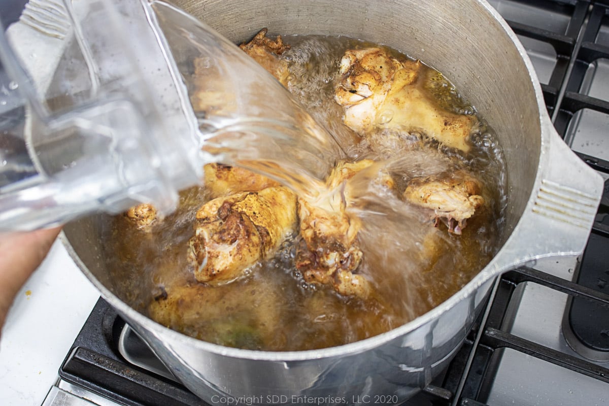 pouring water nto ingredients in a stockpot