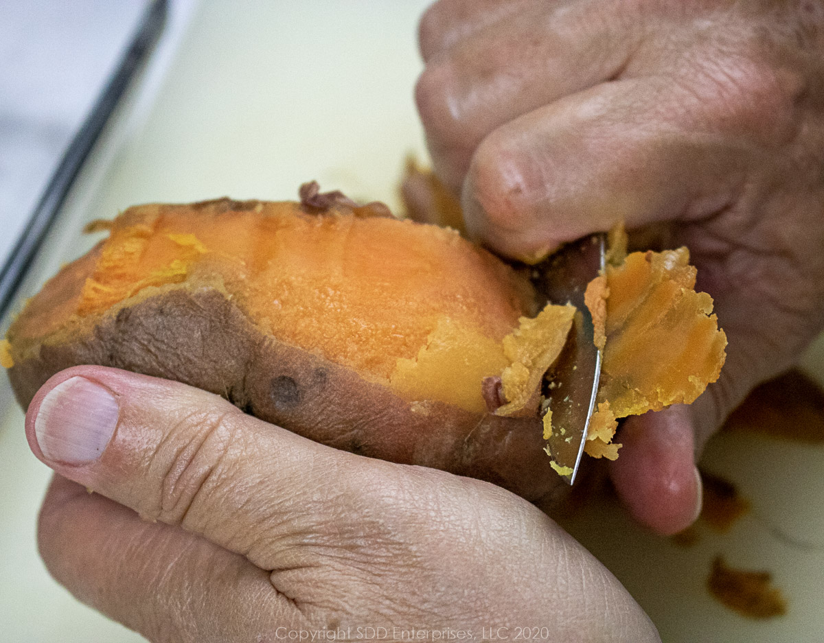 peeling a sweet potato with a paring knife