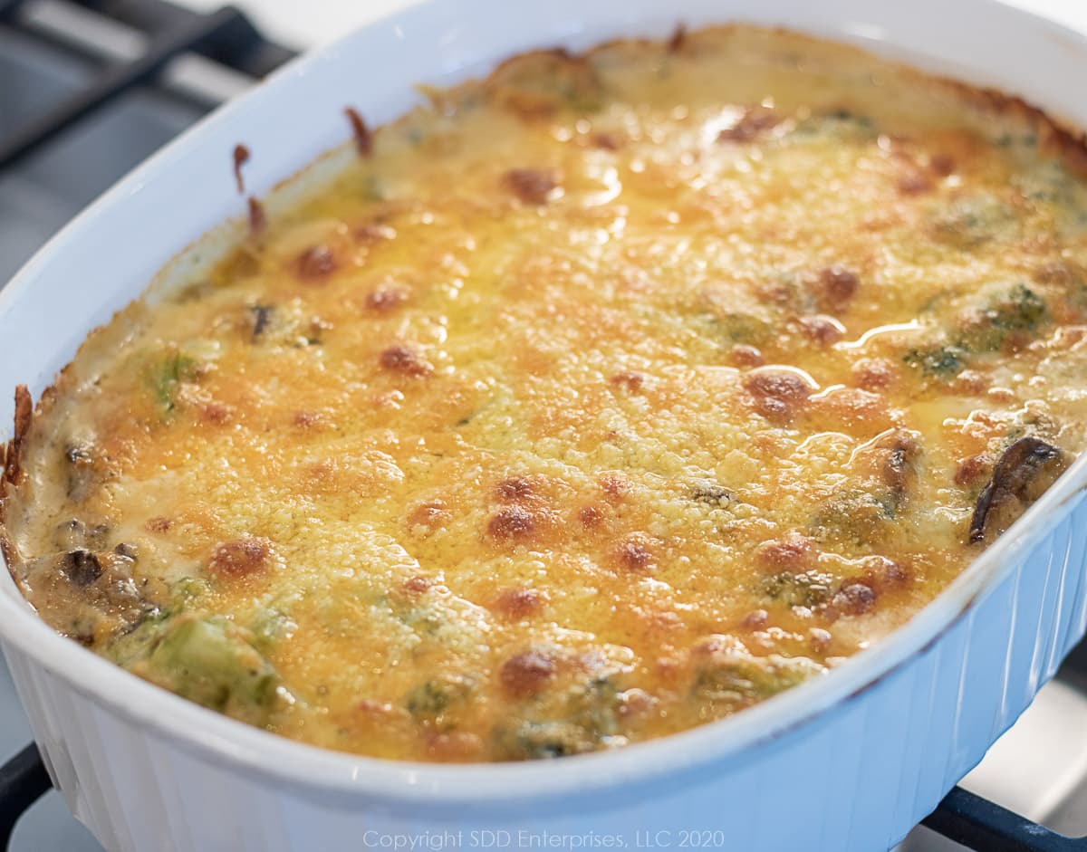baked broccoli cheese casserole in a white baking dish