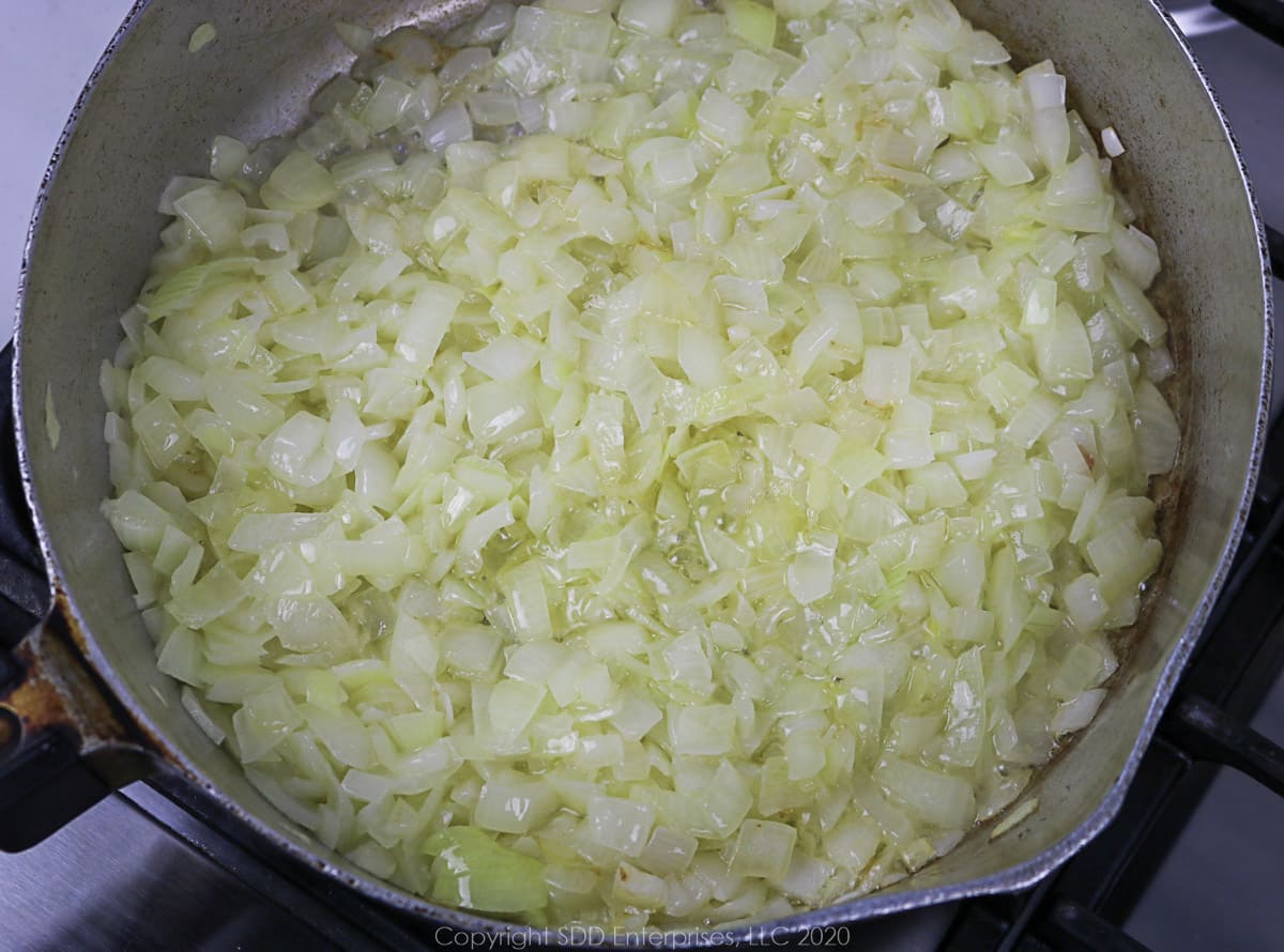 yellow onions sautéing in butter in a frying pan