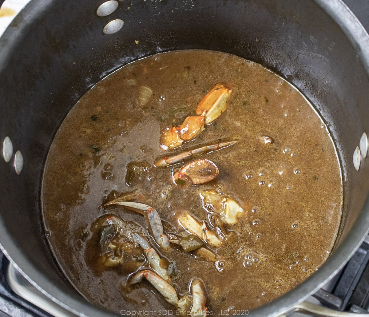 gumbo crabs added to seafood gumbo in a stockpot