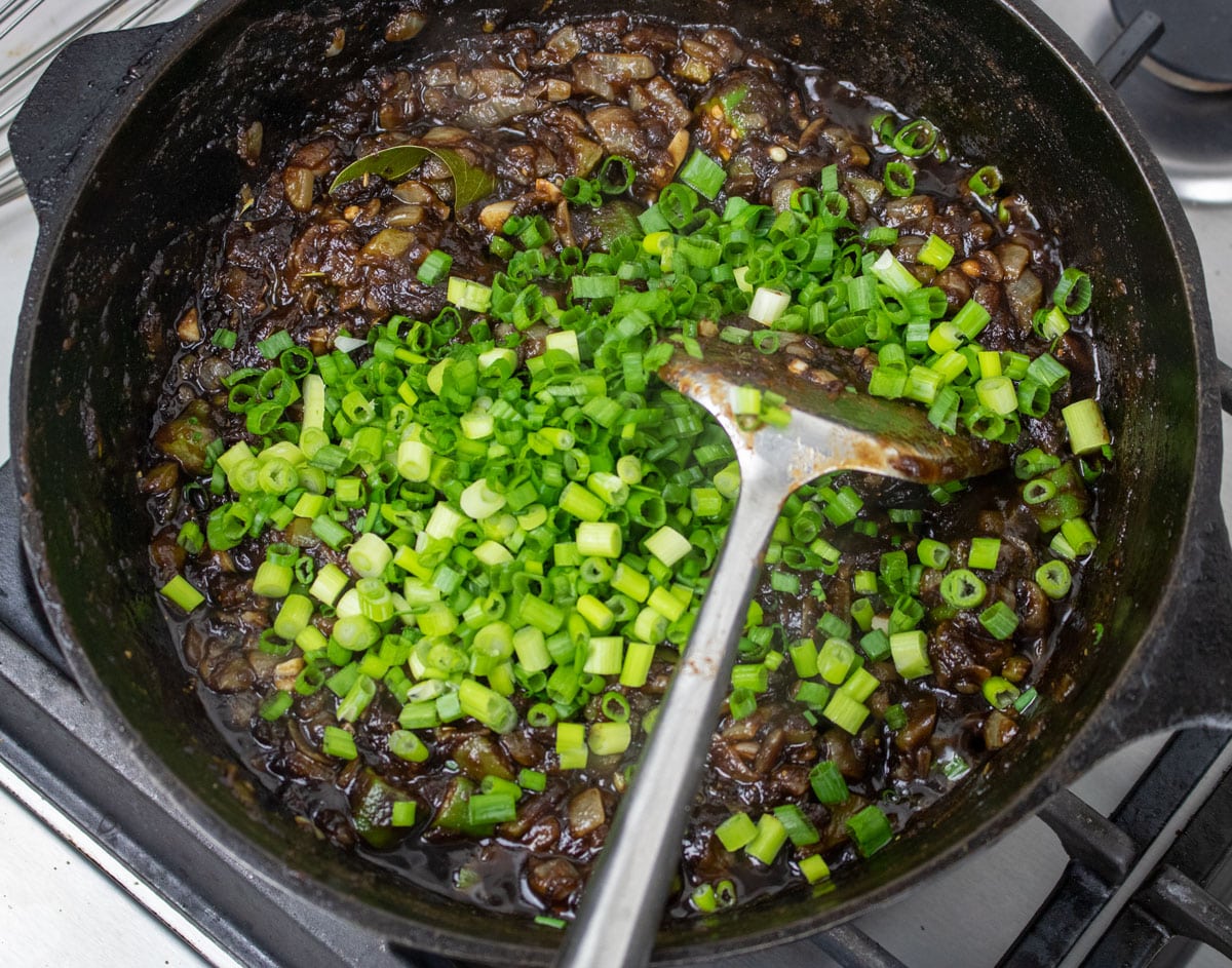 green onions added to roux in a cast iron Dutch oven