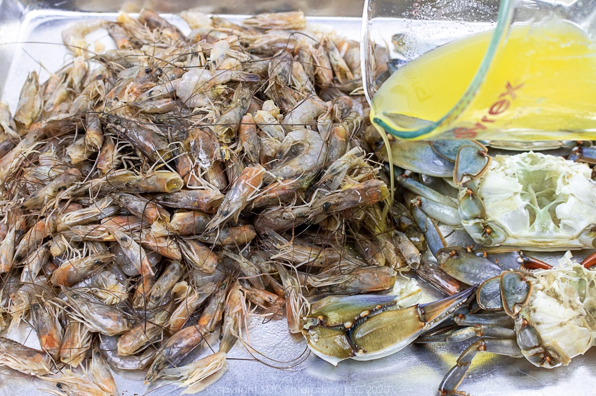 drizzling melted margarine over shrimp and crab shells