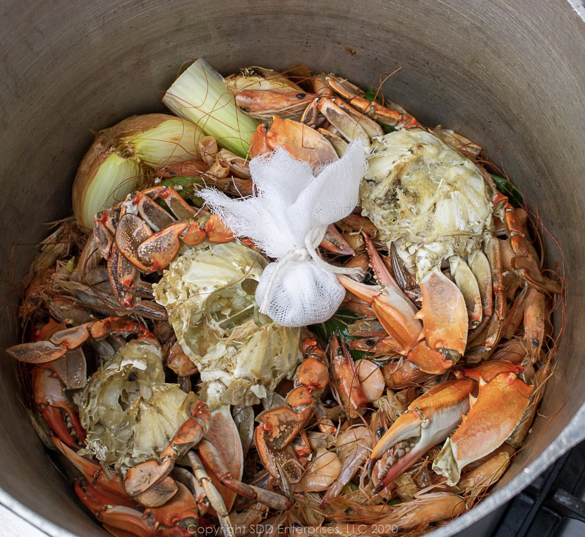 seafood and garni bag in a stockpot wit vegetables for stock