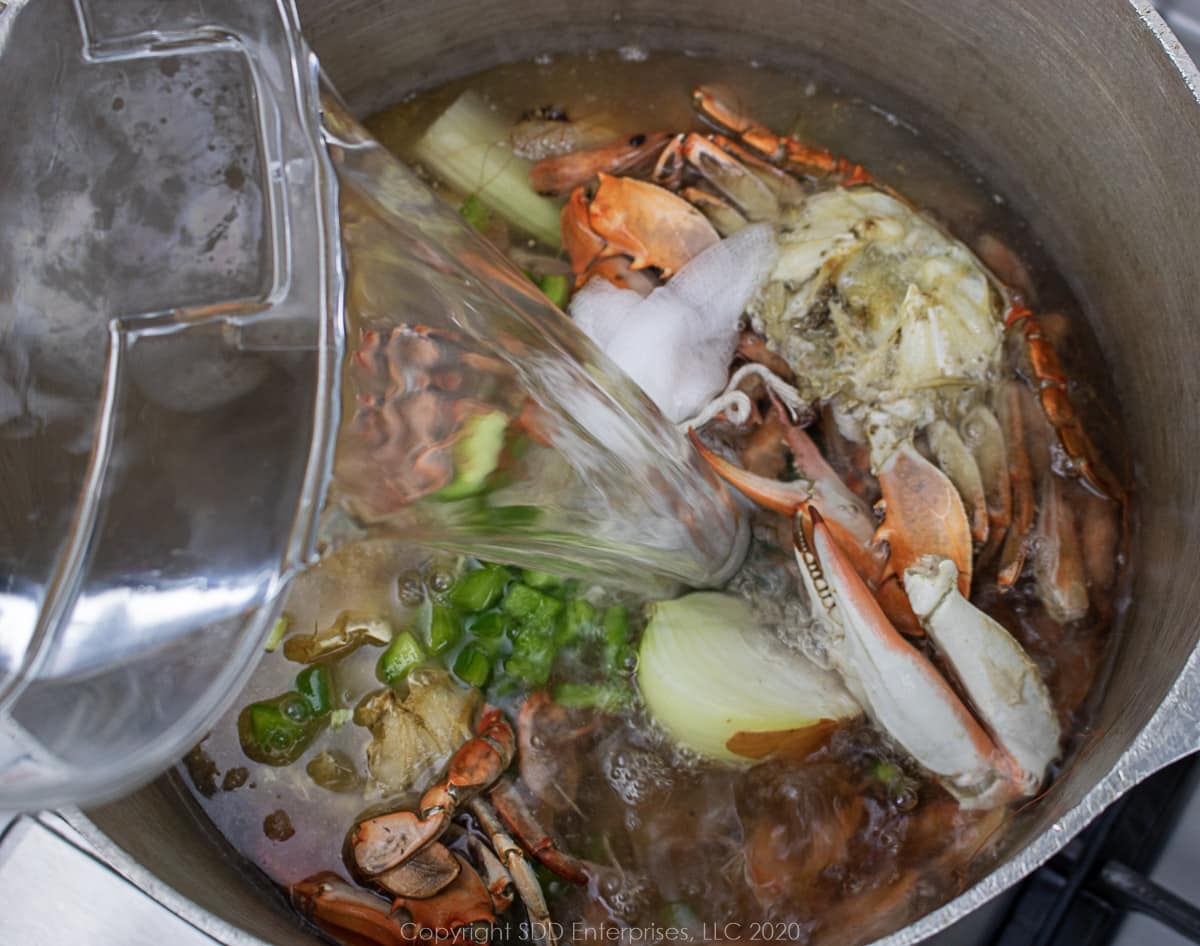 water being added to stockpot for seafood stock