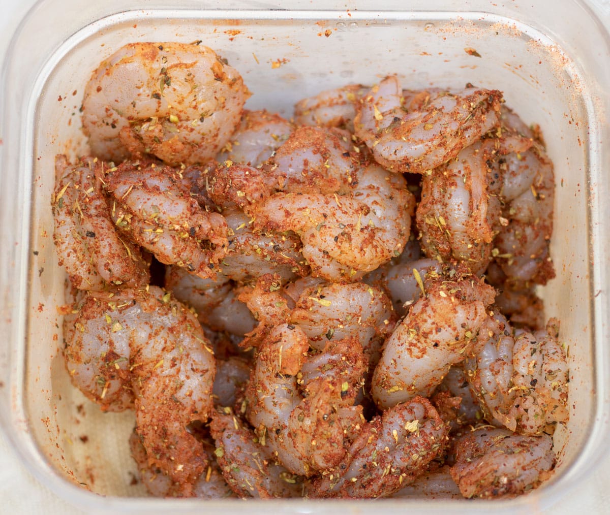 peeled shrimp with Creole seasoning in a prep bowl