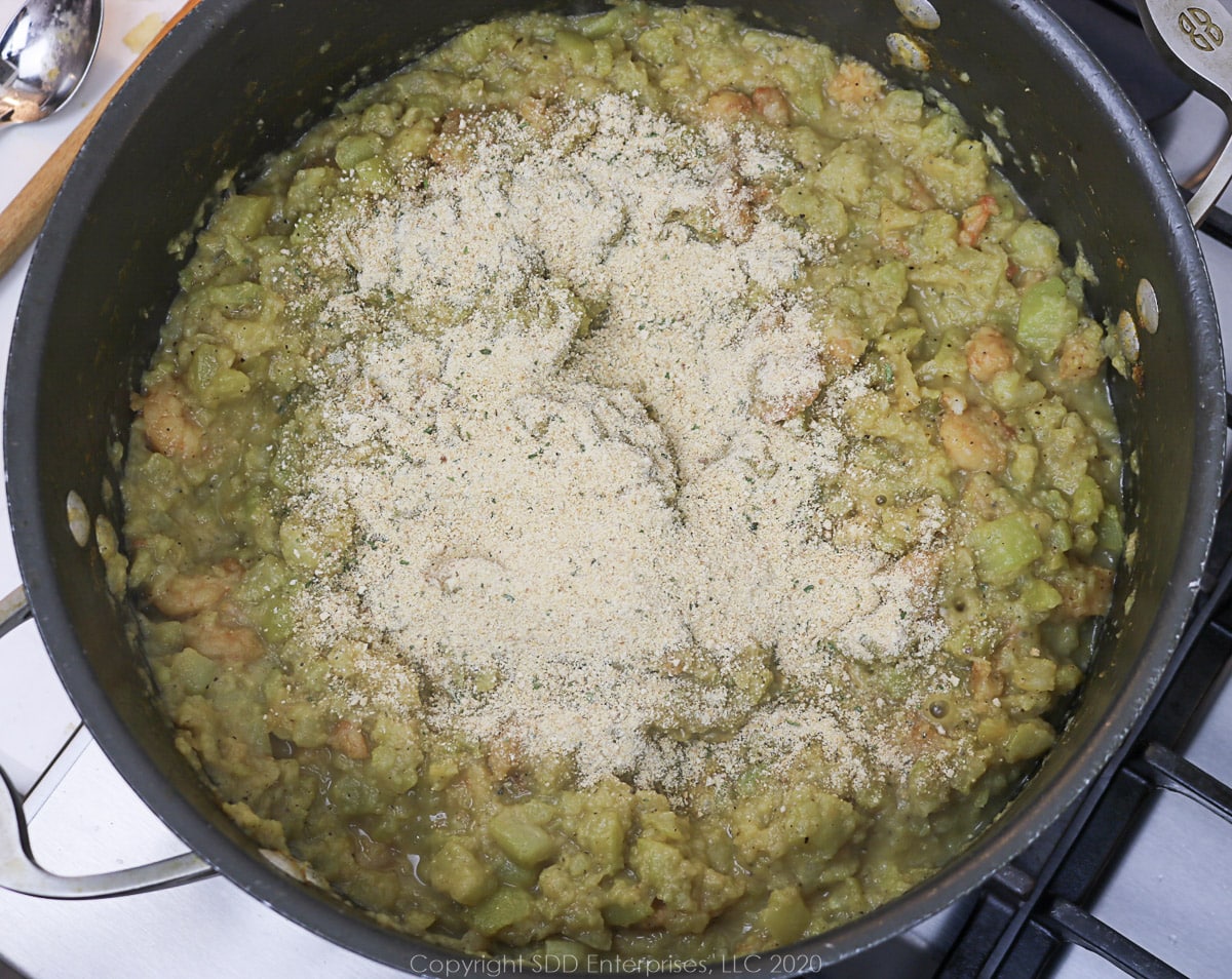 seasoned breadcrumbs added to mirliton mixture in a Dutch oven