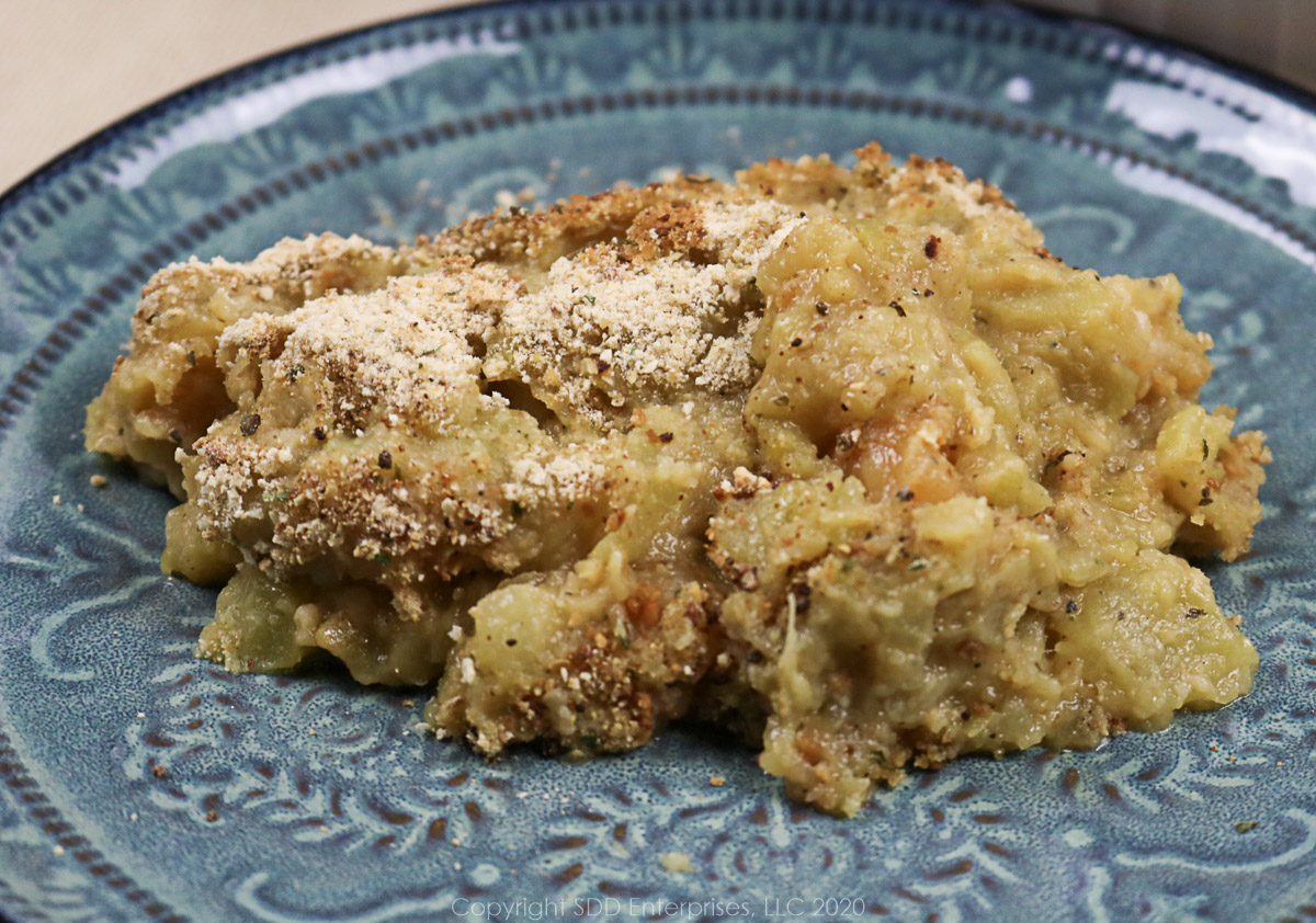 a serving of mirliton casserole with shrimp on a blue plate