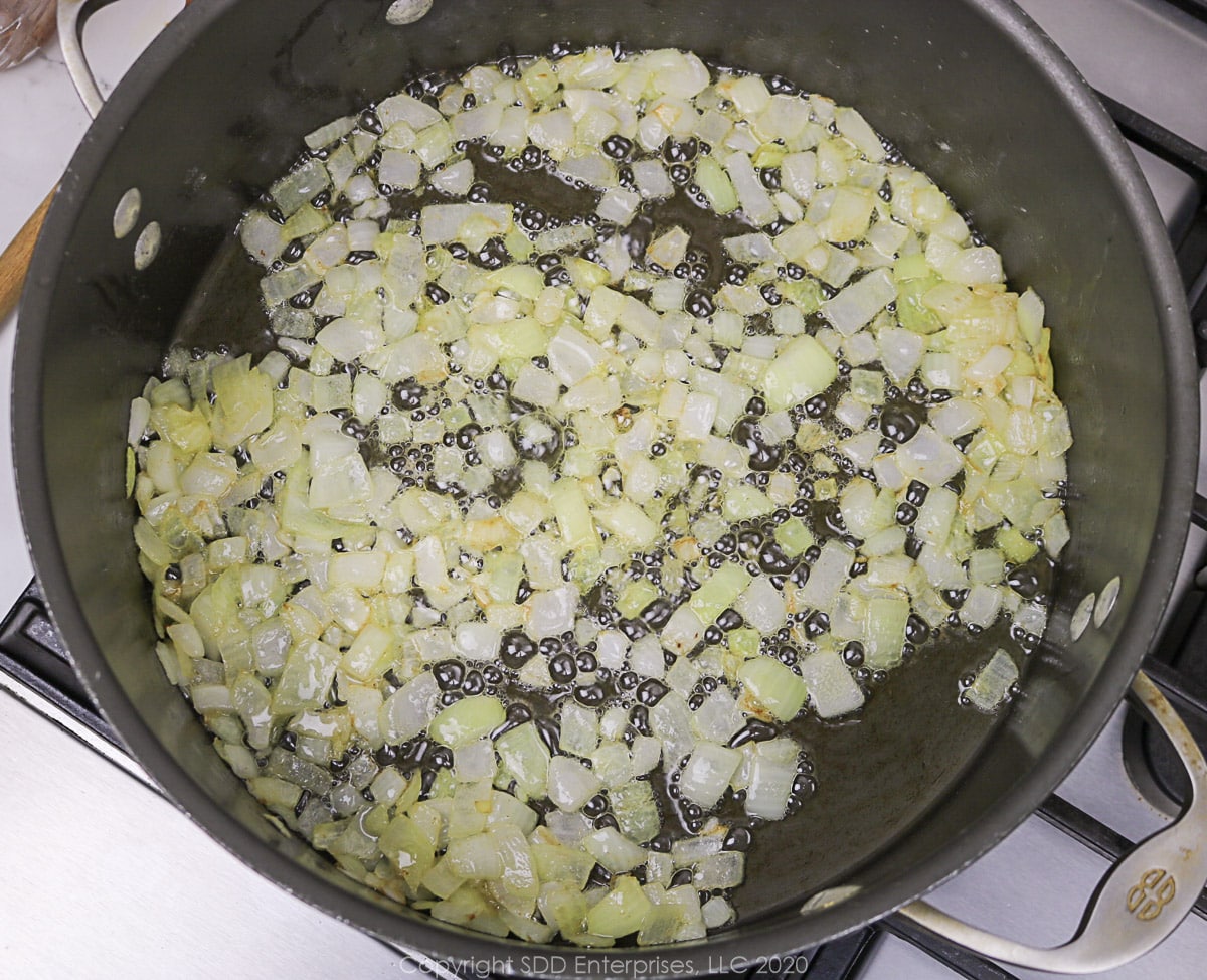 yellow onions sauteing in butter in a Dutch oven