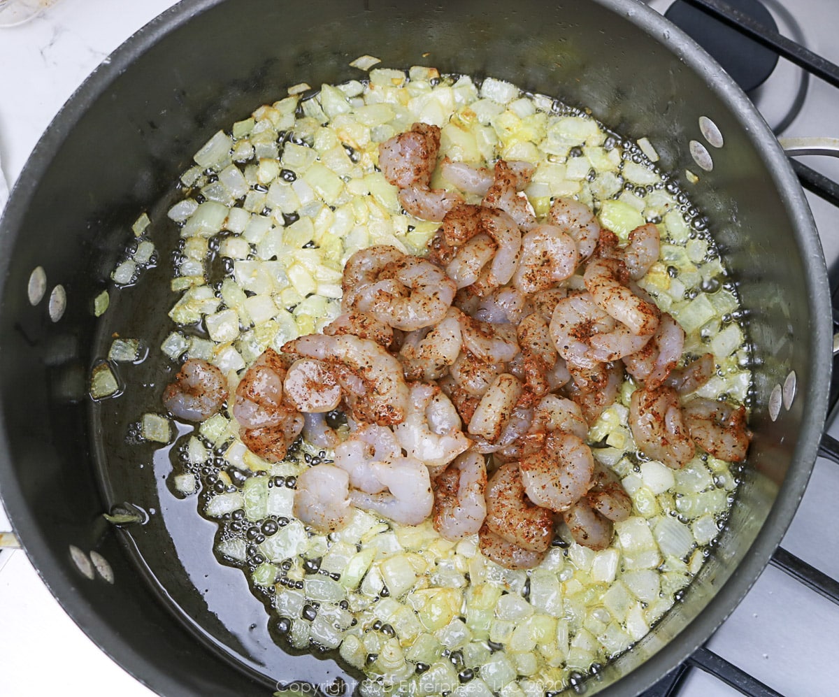 seasoned shrimp added to onions in a Dutch oven