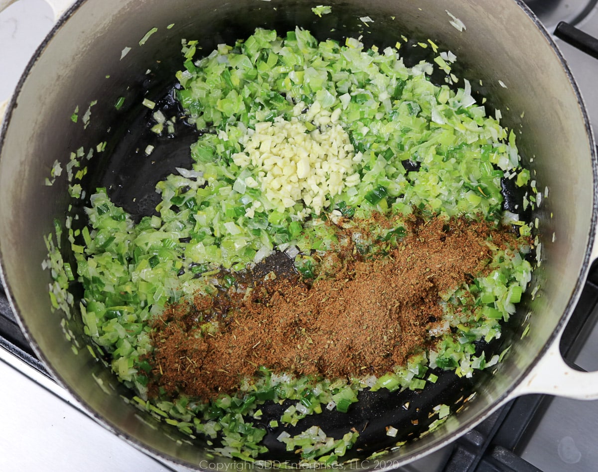 garlic and seasonings added to onions in a dutch oven