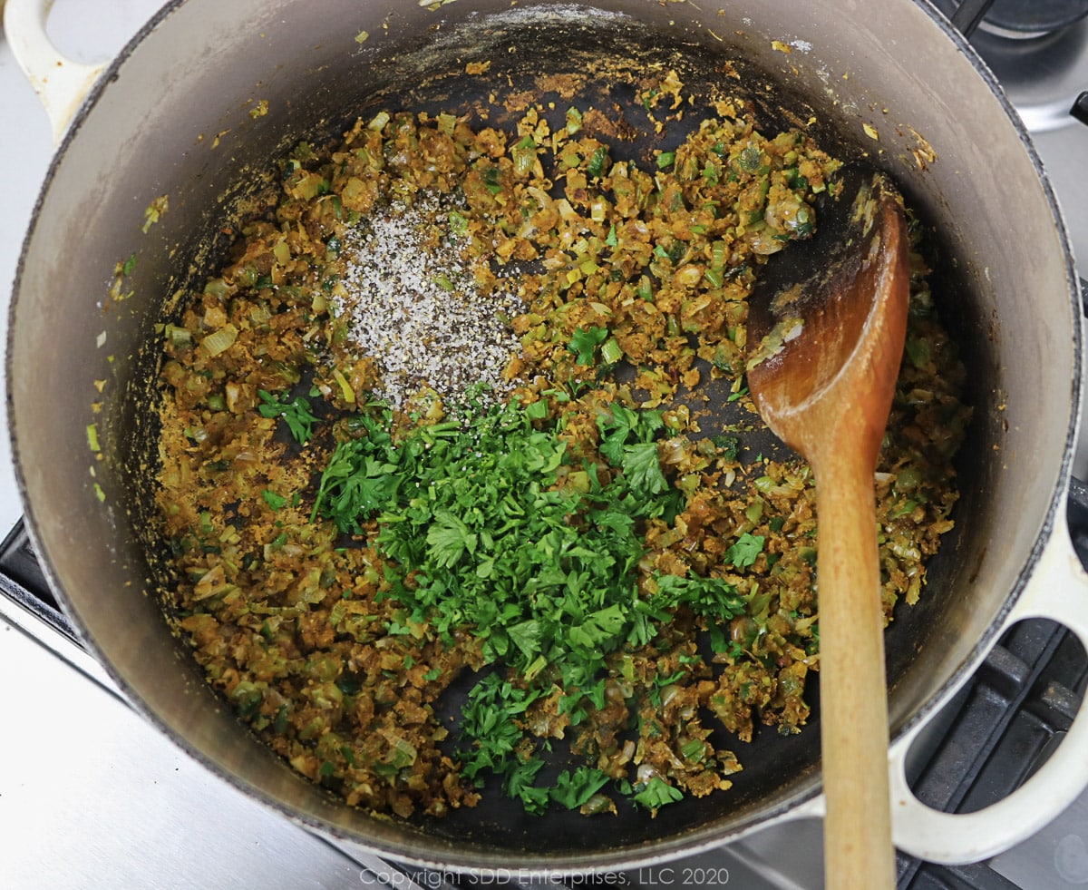 parsley added to suteed onions and flour in a dutch oven