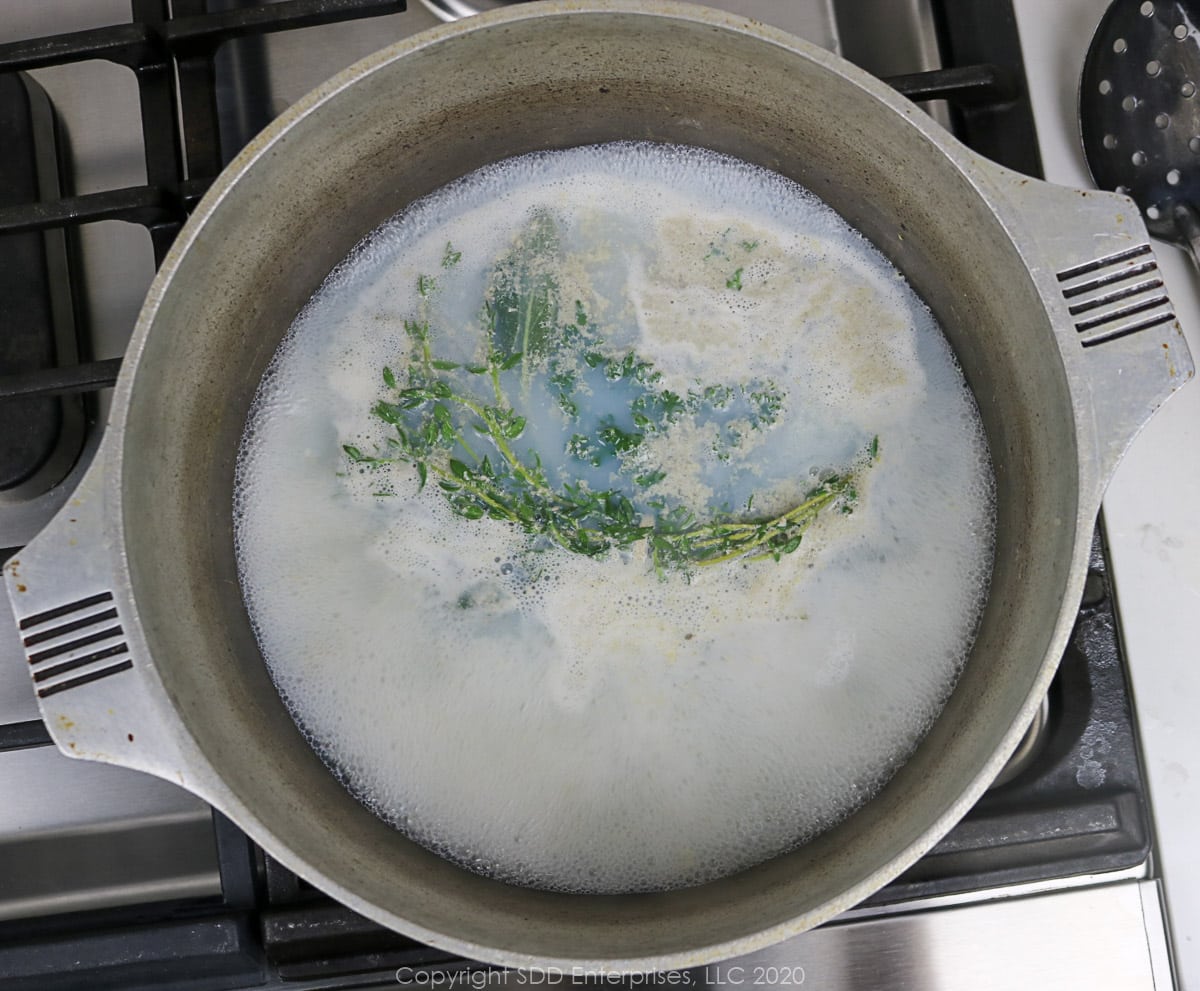 oyster liqour with herbs simmering in a dutch oven