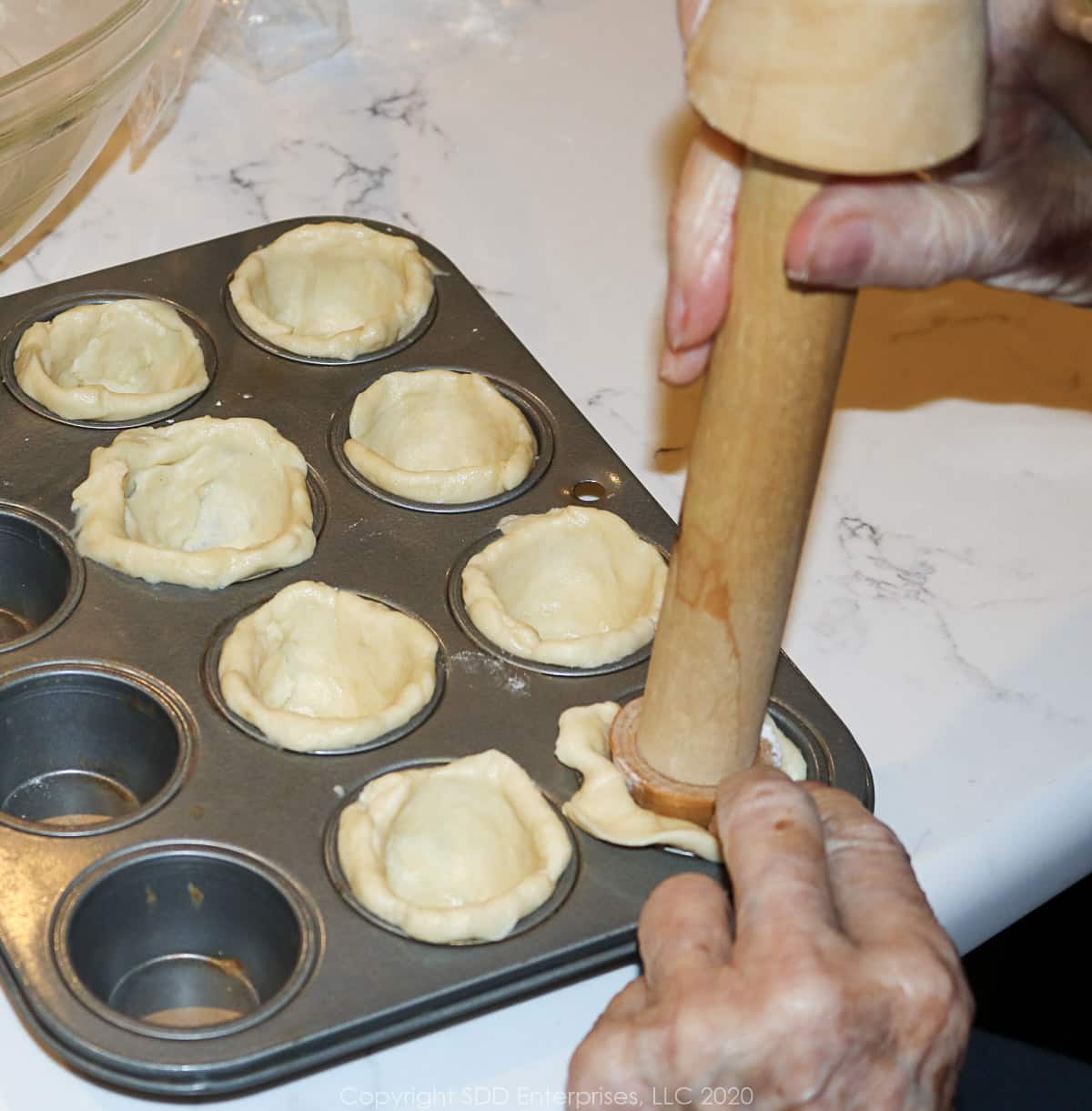 a tart tamper forming the crust for tarts
