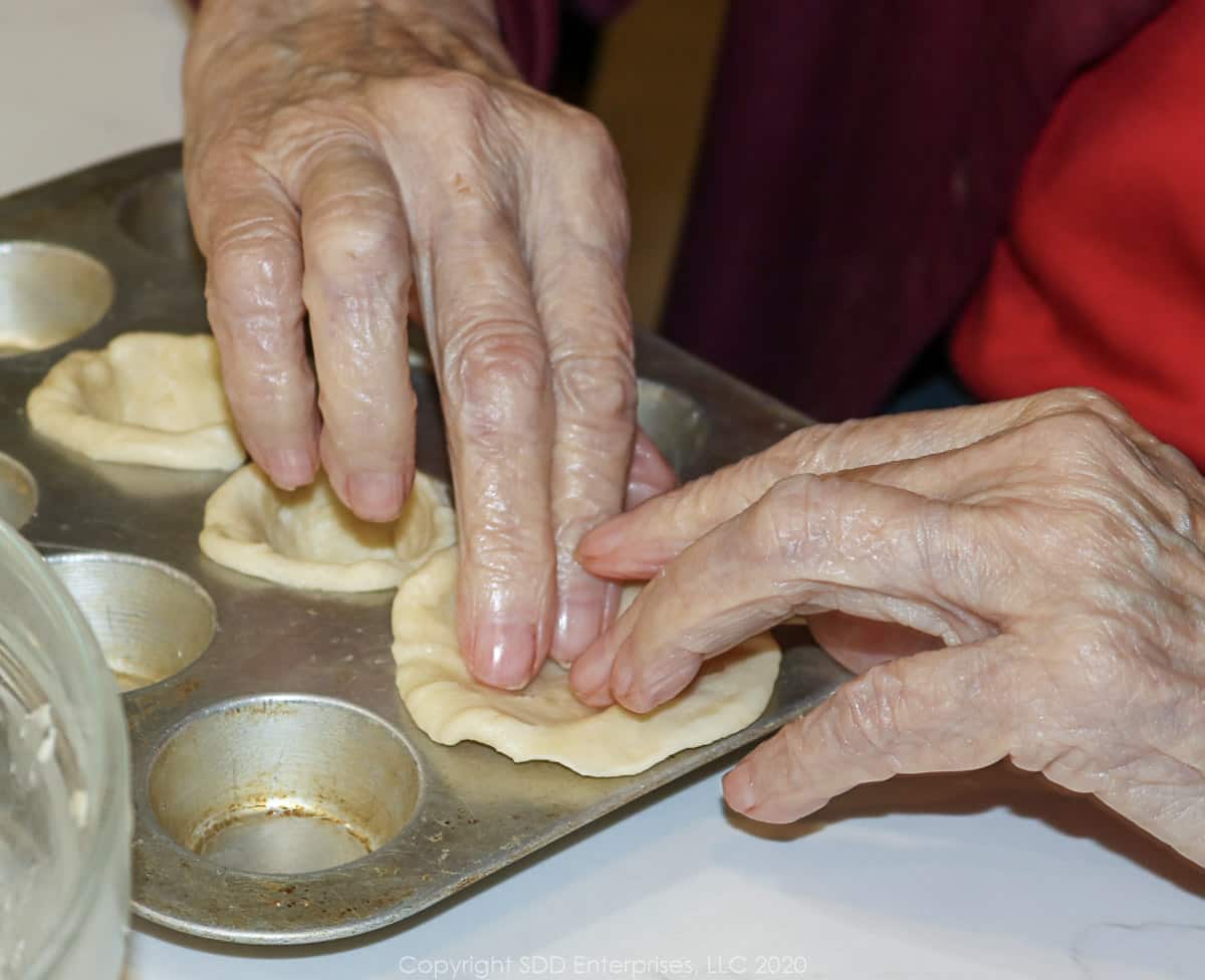 placing dough in mini muffin tins