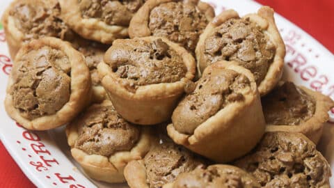 several pecan tarts on a white holiday dish