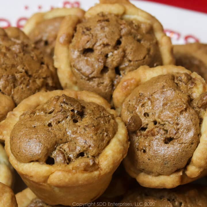 several pecan tarts on a white holiday dish