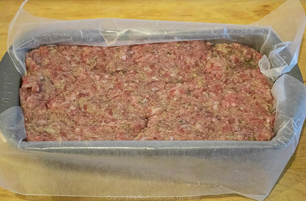 meatloaf mix placed in a loaf pan with wax paper