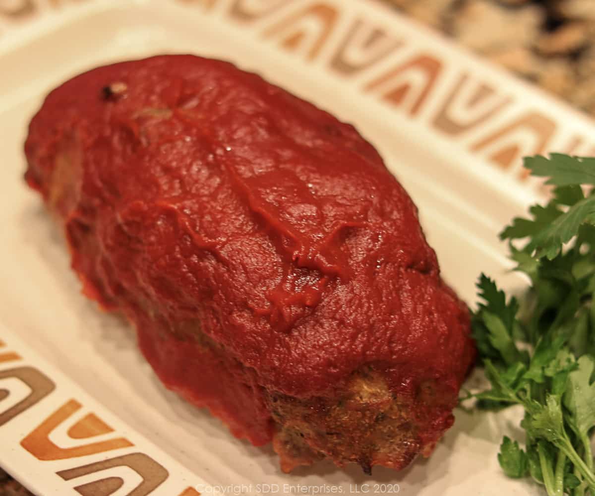 meat loaf with red gravy on a platter