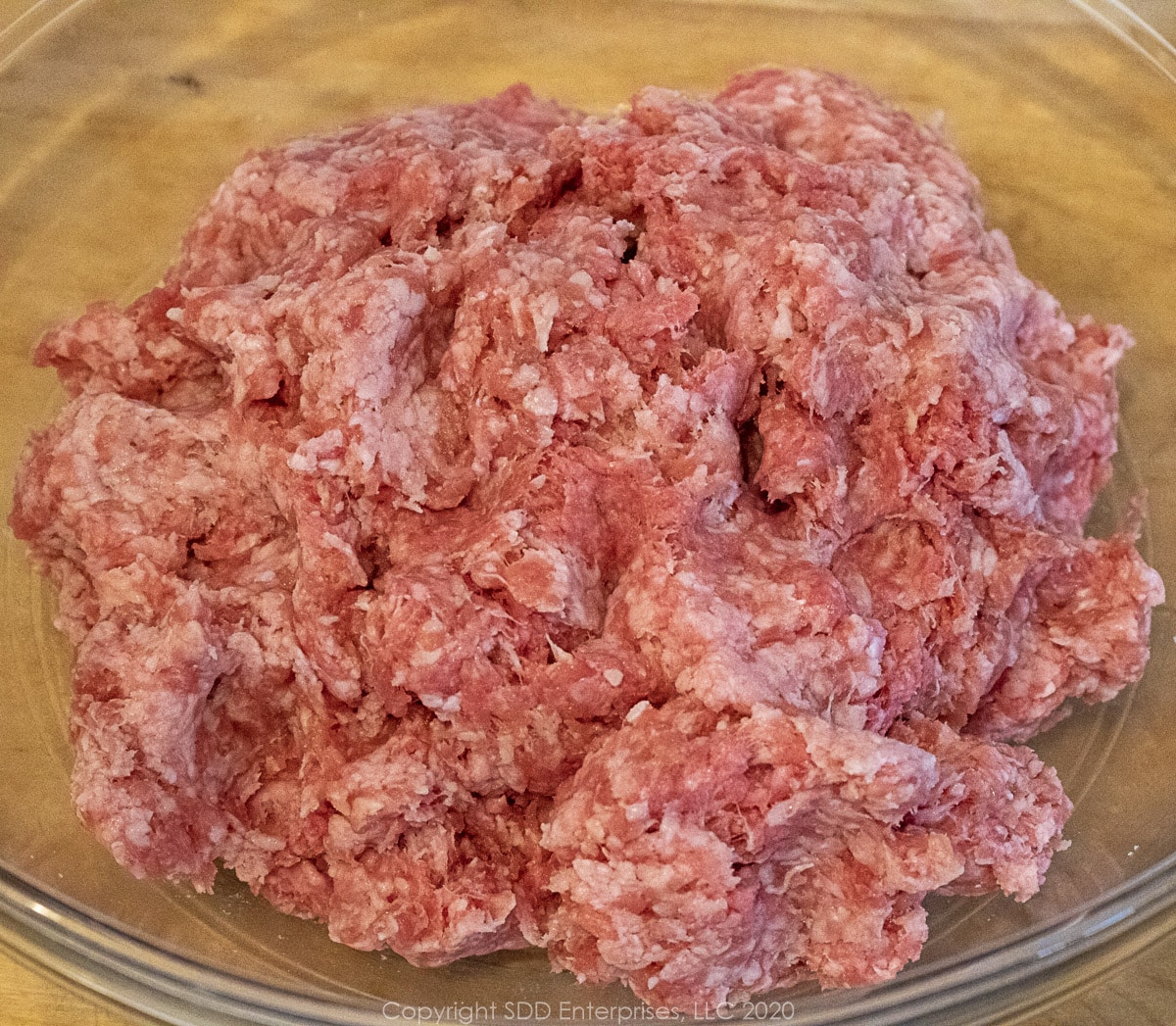 ground beef, porkand veal mix together in a glass bowl