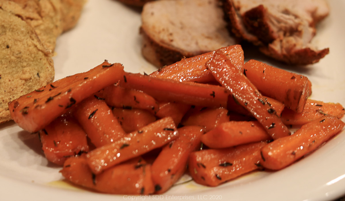 roasted carrots with cane syrup on a plate with pork tenderloin and fried green tomatoes