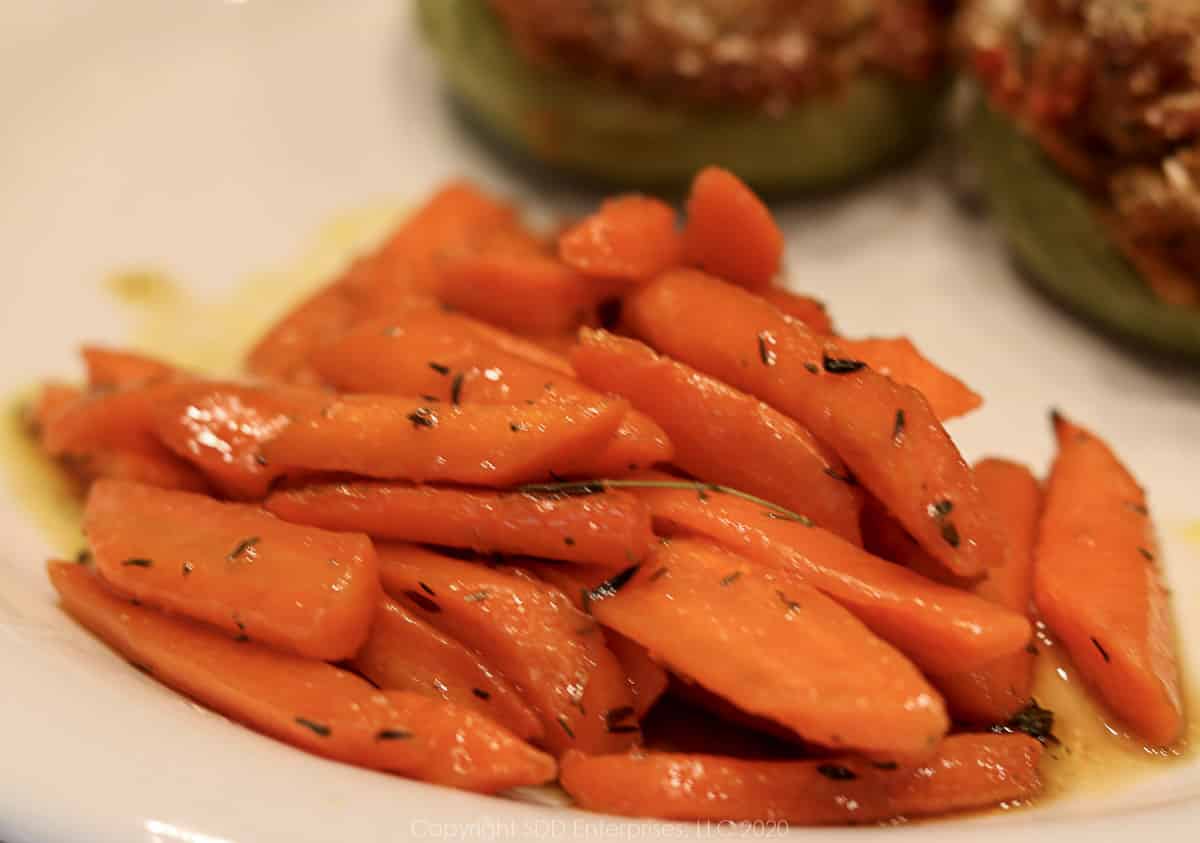 roasted carrots with cane syrup on a plate with stuffed mirliton