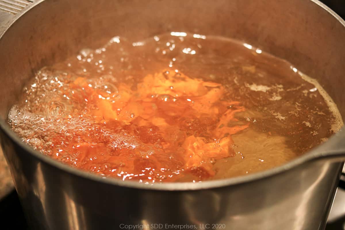 carrots being parboiled in a large stock pot