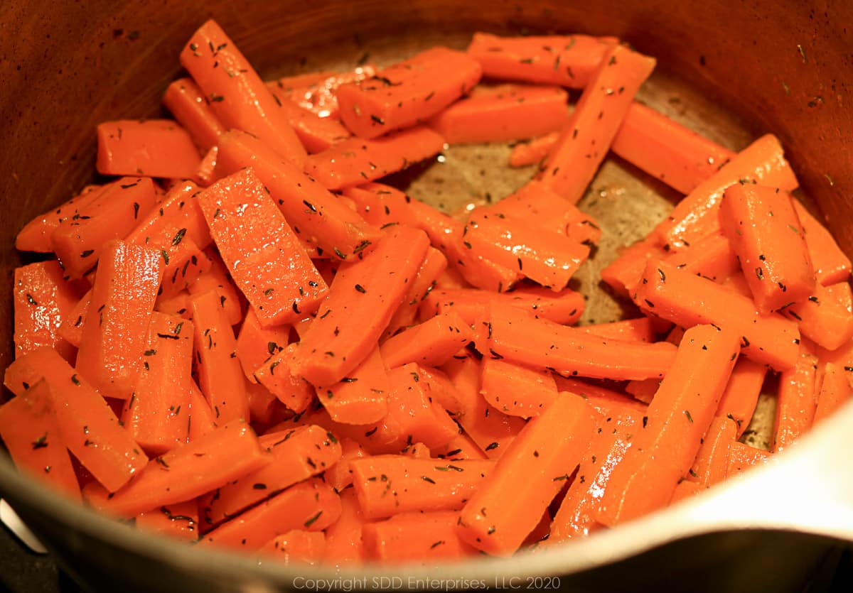 carrots mixed with butter and dry thyme in a large stock pot