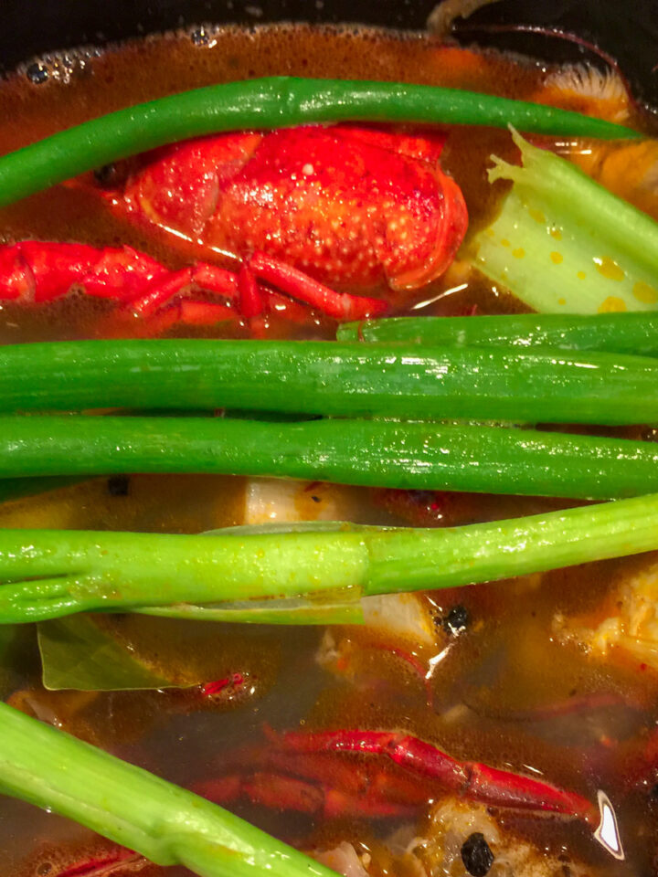 crawfish shells, green onions, yellow onions and celery with water in a stock pot