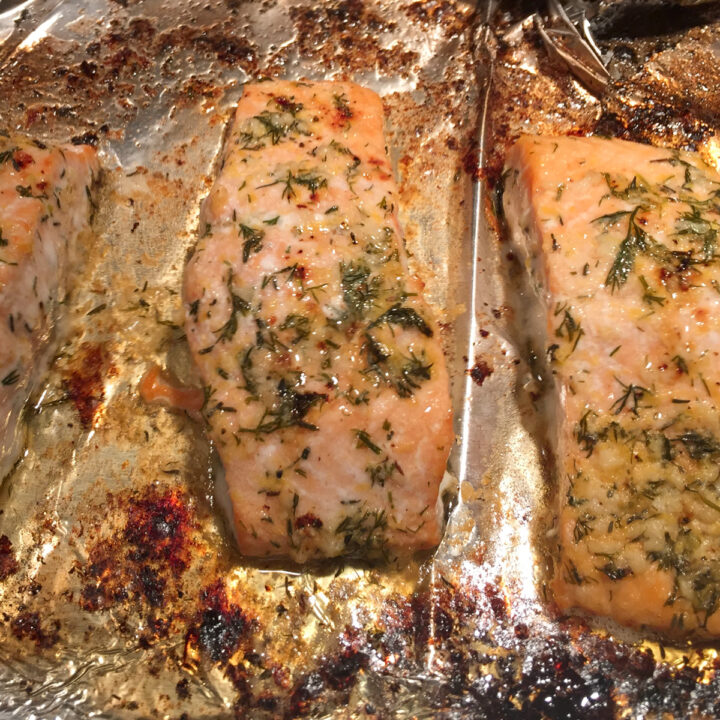 baked salmon fillets with herb butter on a baking sheet