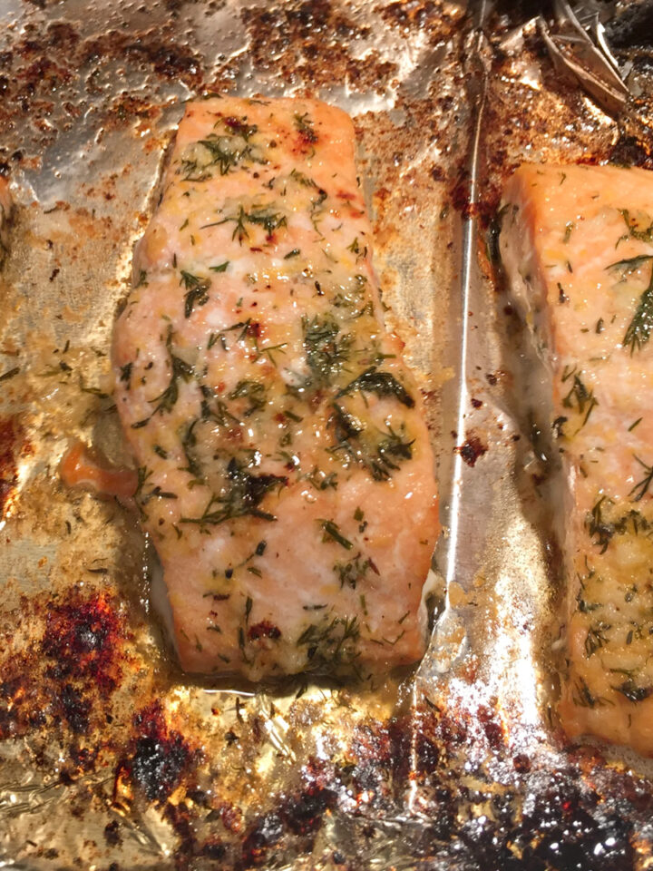 baked salmon fillets with herb butter on a baking sheet