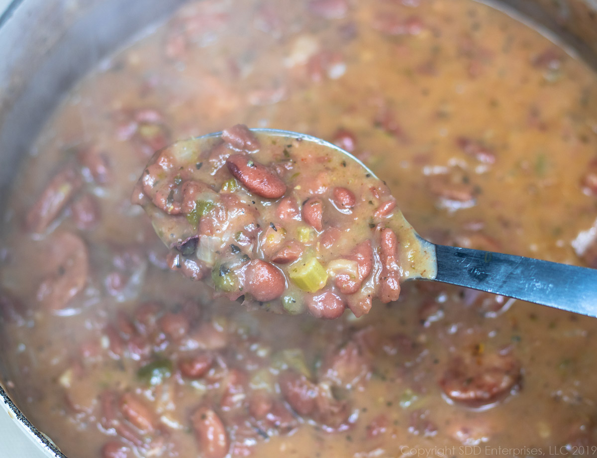 a spoon of red beans over a Dutch oven